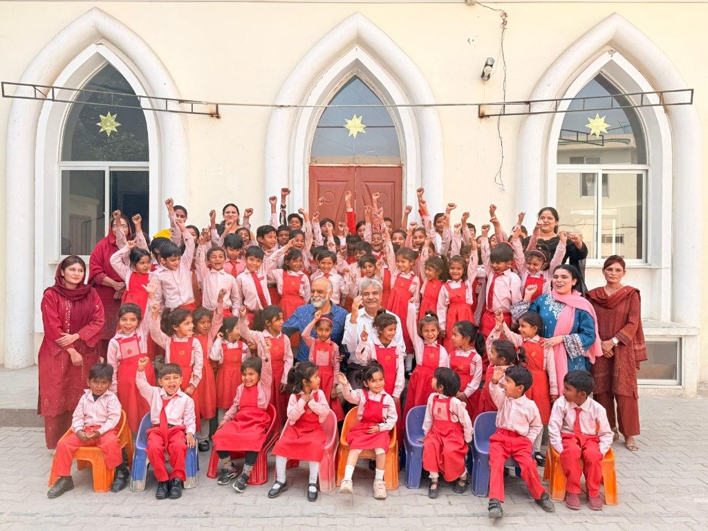 Joyful community school students with hands raised cheering
